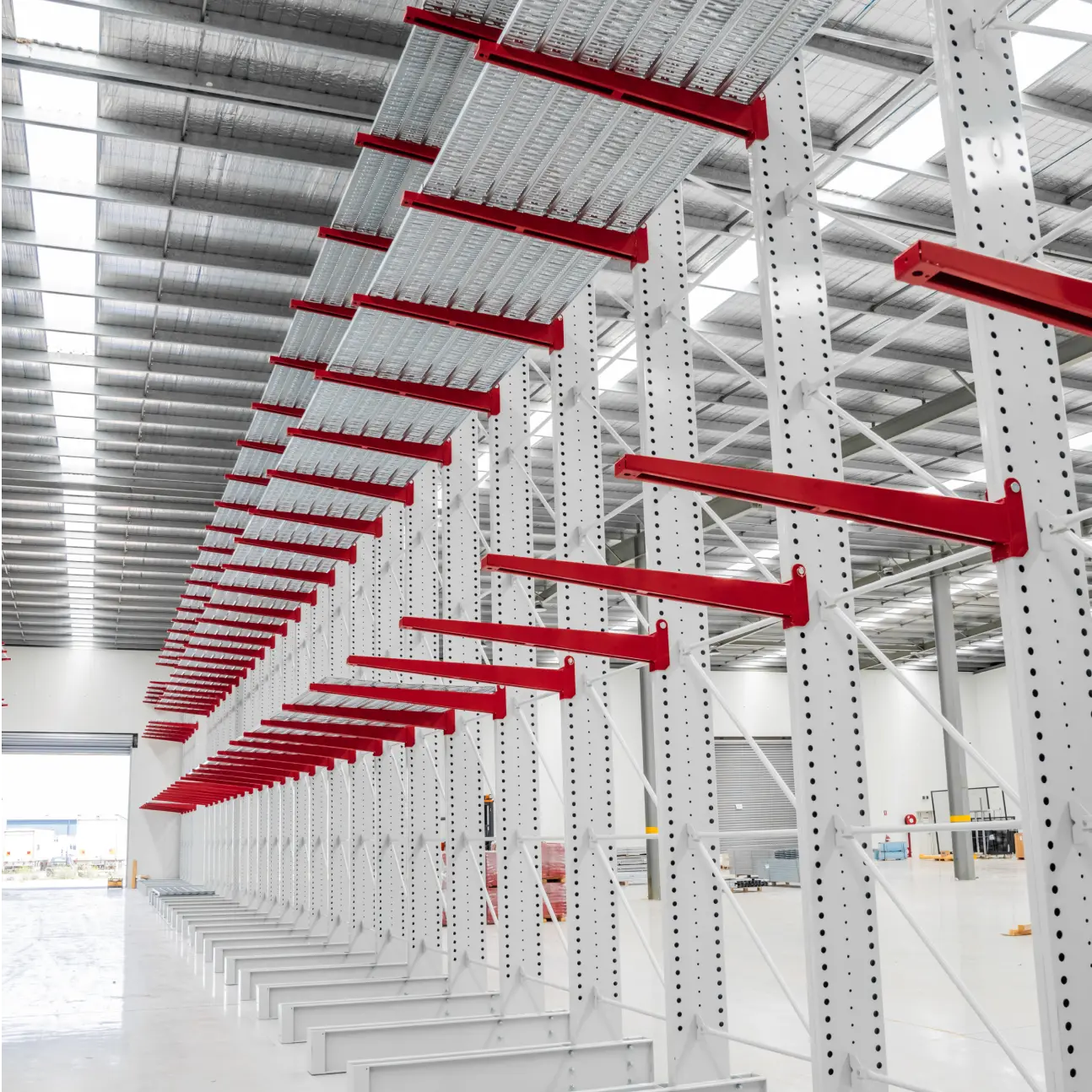 Large warehouse cantilever racking system with red arms for long item storage